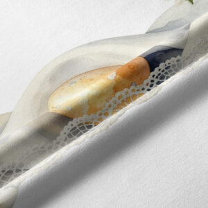 Zbliżenie na nadruk pisanek i misterną koronkową tasiemkę, detal tkaniny