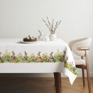 Aranżacja stołu ze świątecznym obrusem, koszykiem z pisankami i prostą dekoracją na środku