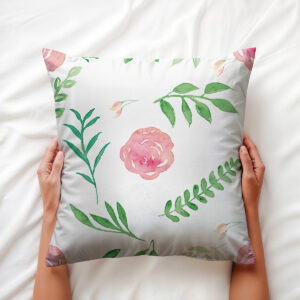 Poduszka dekoracyjna z motywem akwarelowych róż trzymana w dłoniach, widok z góry na wzór