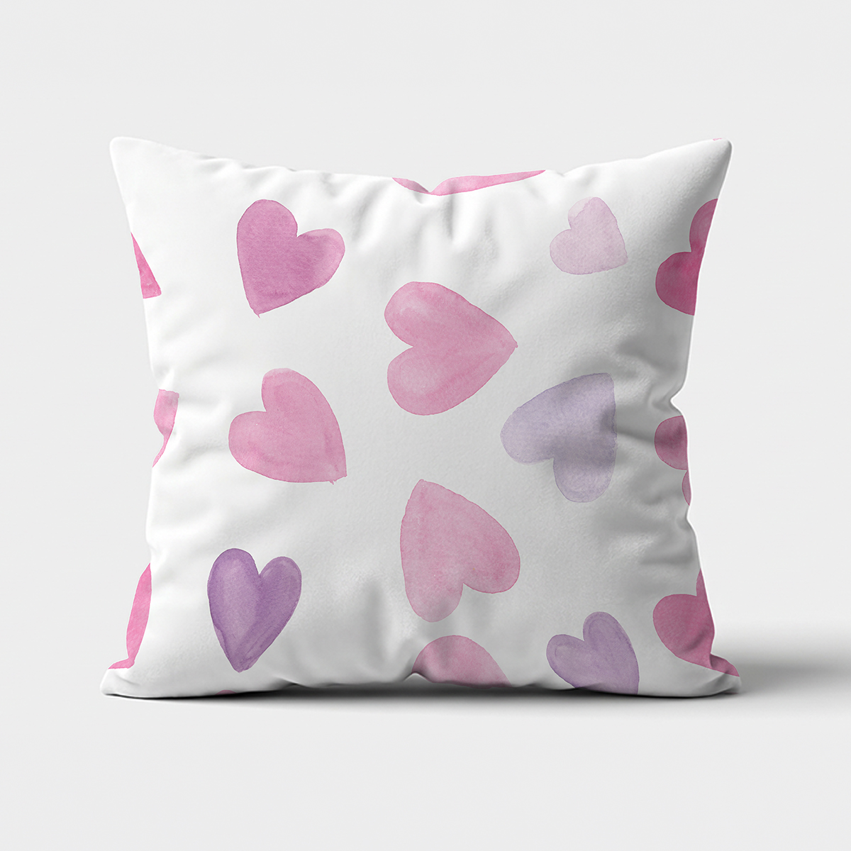 Poduszka ozdobna z różowo-fioletowymi akwarelowymi sercami na białym tle, widok z przodu