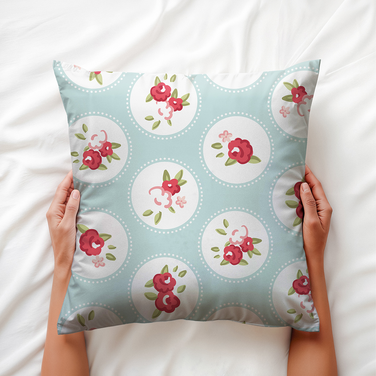 Dłoń trzymająca poduszkę, detal wzoru z medalionami i kwiatami na miętowym tle