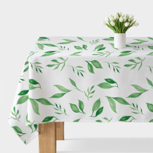Obrus z akwarelowymi zielonymi listkami ułożony na stole z białym wazonem i tulipanami