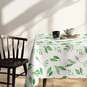 Słoneczne ujęcie stołu z obrusem, widoczne liściaste motywy na białym tle