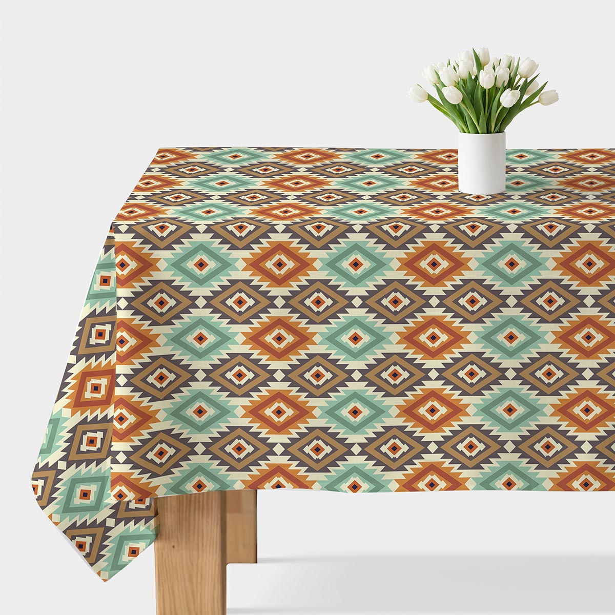 obrus na stole z azteckim geometrycznym wzorem i białym wazonem z tulipanami