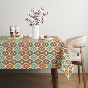 stół nakryty obrusem w jadalni z krzesłem i suszonymi gałązkami w wazonie