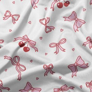 Zbliżenie na tkaninę z detalami kokardek, wisienek i maleńkich serduszek