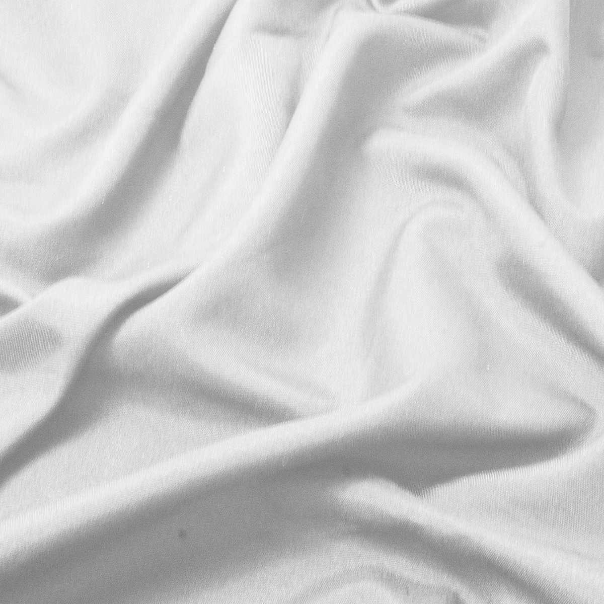 Zbliżenie na gładką białą tkaninę obrusu pokazujące delikatną fakturę