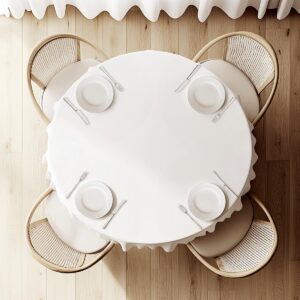 Widok z góry na okrągły stół z białym obrusem i zastawą dla czterech osób