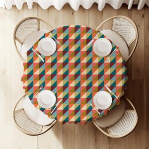 widok z góry na okrągły stół nakryty obrusem z geometrycznym wzorem i nakryciami