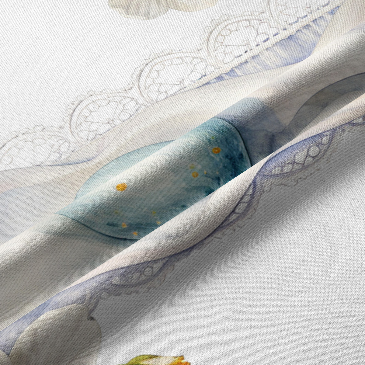 Zbliżenie tkaniny pokazujące akwarelową pisankę i delikatny koronkowy wzór na plamoodpornej tkaninie