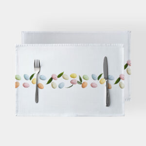 Białe podkładki ze wzorem pastelowych pisanek i zielonych listków, widok z góry