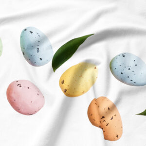 Zbliżenie na pastelowe pisanki i fakturę gładkiej tkaniny podkładki