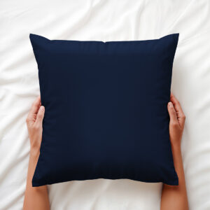 poduszka dekoracyjna trzymana w dłoniach na pościeli, widoczne gładkie wykończenie