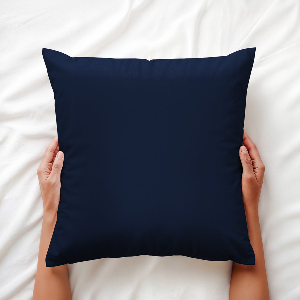 poduszka dekoracyjna trzymana w dłoniach na pościeli, widoczne gładkie wykończenie