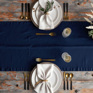 Aranżacja stołu z granatowym bieżnikiem, białe talerze i złote sztućce