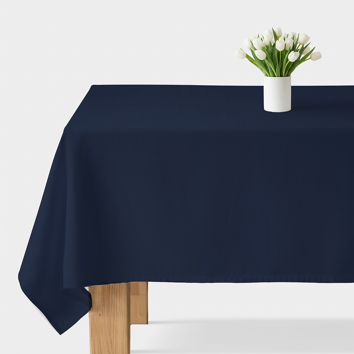 granatowy gładki obrus widok frontalny na stole z białym wazonem tulipanów