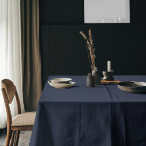 aranżacja stołu z obrusem, ceramiczne naczynia i dekoracje w stonowanym wnętrzu