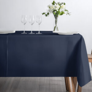 stół przykryty obrusem z trzema kieliszkami i bukietem kwiatów jako dekoracją