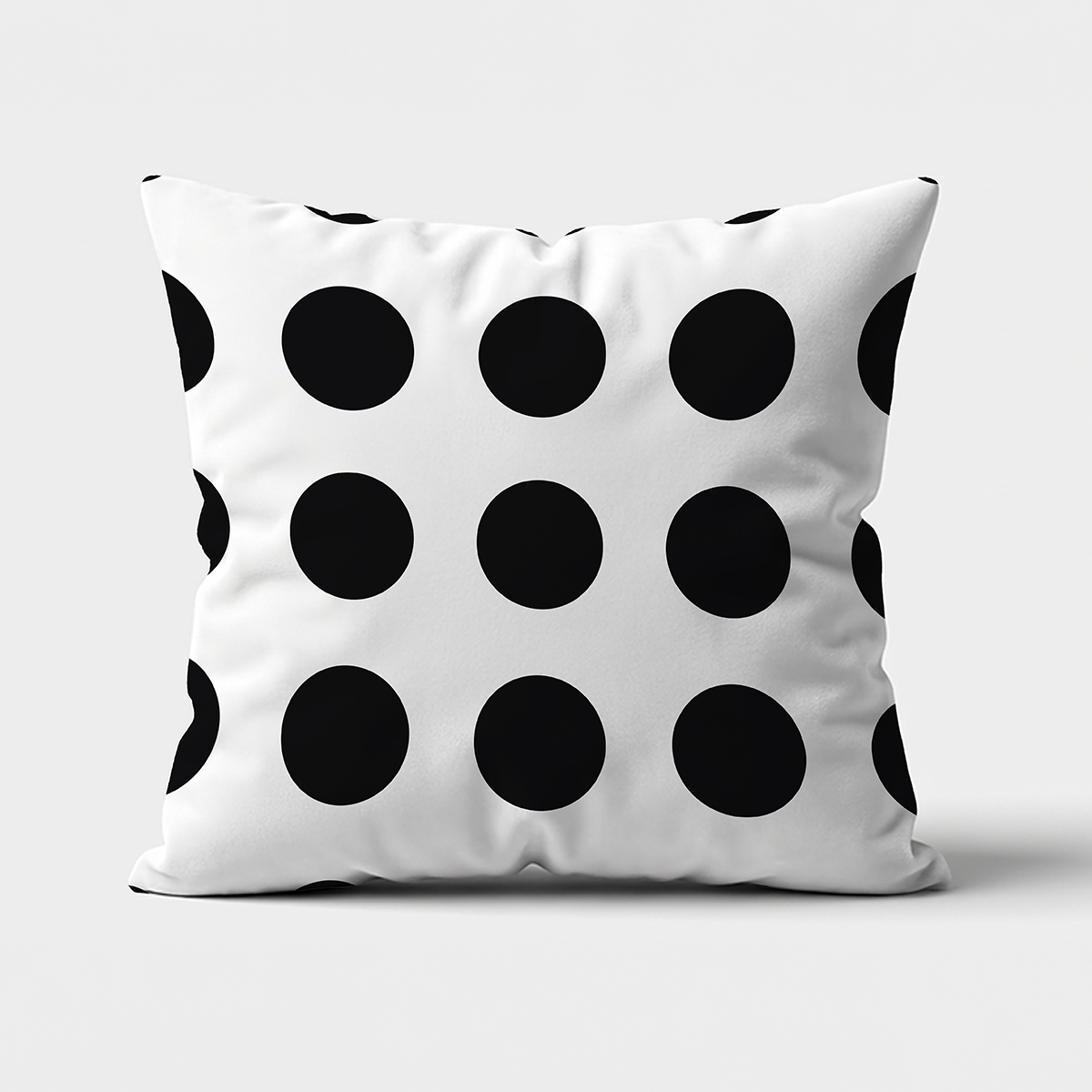 Poduszka dekoracyjna z dużymi czarnymi groszkami na białym tle — widok z przodu