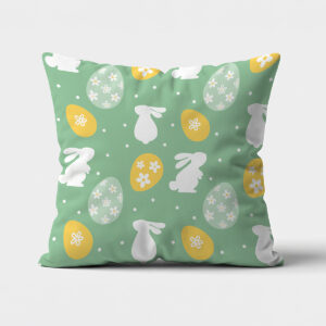 Miętowa poduszka z białymi sylwetkami króliczków i żółtymi pisankami, widok frontalny