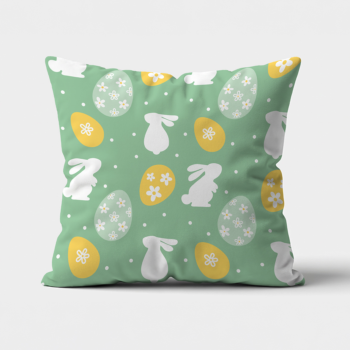 Miętowa poduszka z białymi sylwetkami króliczków i żółtymi pisankami, widok frontalny