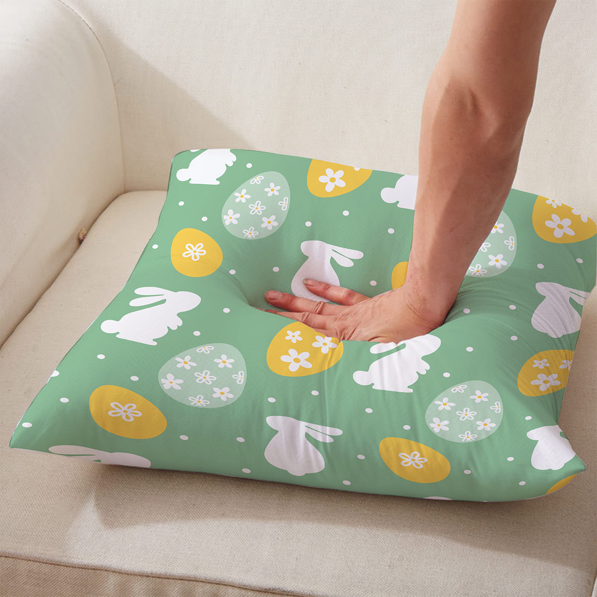 Ręka ugniata poduszkę, pokazanie miękkości materiału i sprężystości wypełnienia