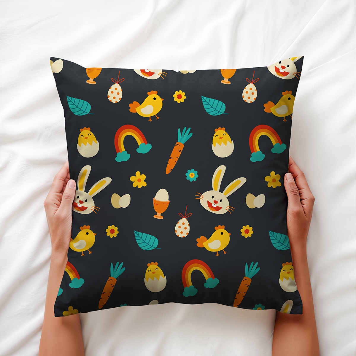 Poduszka trzymana w dłoniach z widocznym wzorem z uśmiechniętym zajączkiem i żółtym pisklęciem