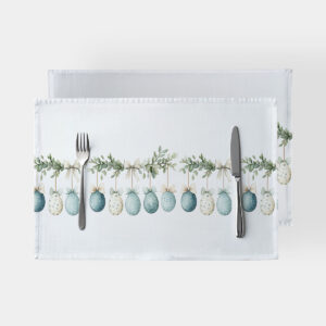 Podkładki ze wzorem wiszących pisanek i kokard na białym tle, ujęcie z widocznym sztućcem