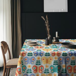 Aranżacja stołu z zastawą na obrusie w geometryczne motyle, stylowe dodatki dekoracyjne