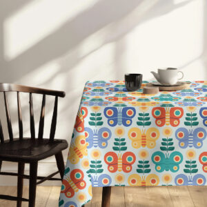 Krawędź obrusu i narożnik stołu z wzorem motyli, kompozycja z krzesłem w tle