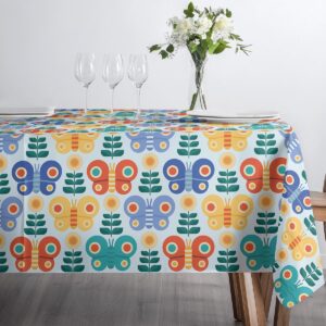 Ujęcie stołu z filiżankami i szklankami na obrusie z motywem motyli i kwiatów