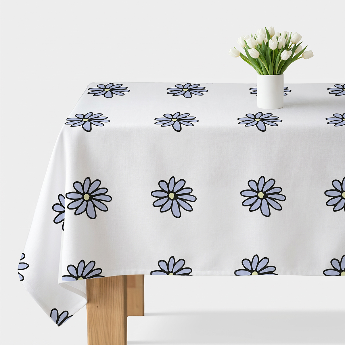 biały obrus na stole z regularnie rozmieszczonymi stokrotkami w lawendowym odcieniu