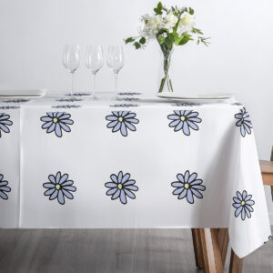 ujęcie z góry z kieliszkami i wazonem na obrusie w drobne stokrotki