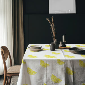 Aranżacja stołu z talerzami i dekoracjami na obrusie z cytrynami