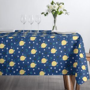 Detal wzoru obrusu z plasterkami cytryny i zielonymi listkami przy zastawie do kawy