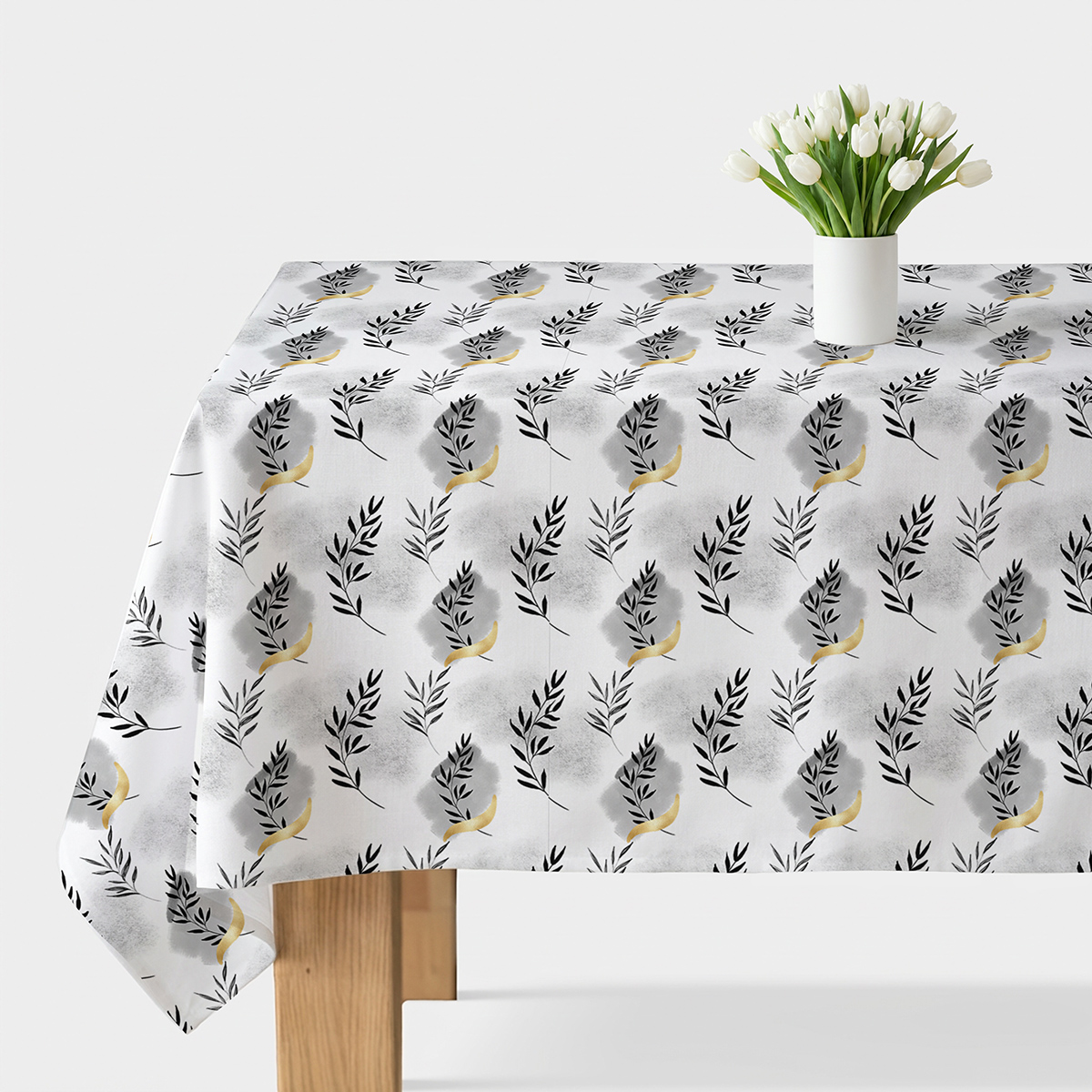 biały obrus z czarnymi gałązkami i złotymi akcentami na stole z bukietem białych tulipanów