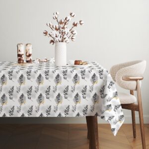 detal materiału obrusu pokazany przy talerzach i wazonie z bawełnianymi kwiatami