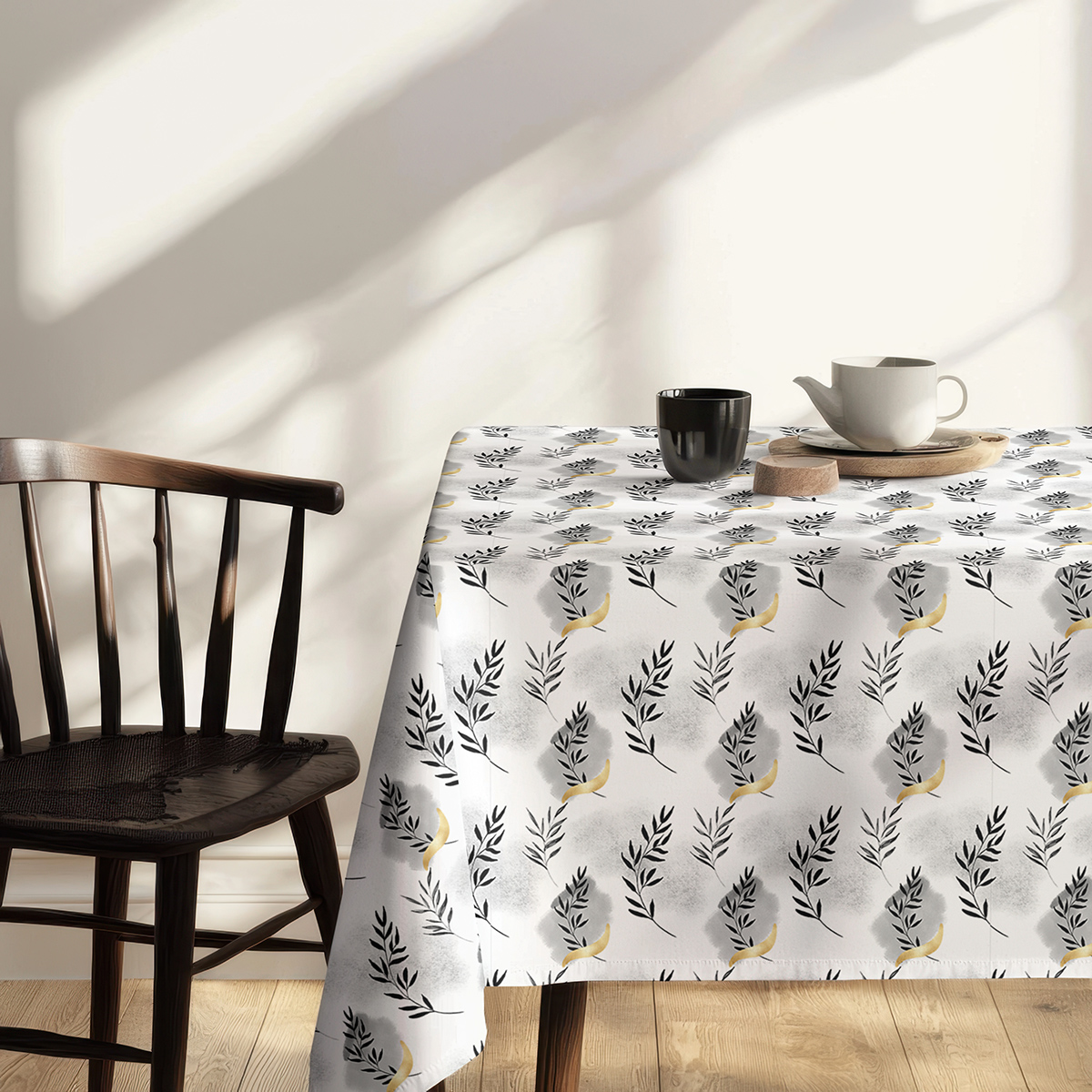 skrócony róg obrusa na tle krzesła, widoczny wzór gałązek i złote akcenty