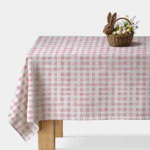 stół nakryty obrusом w różowo-białą kratę z koszykiem wielkanocnym z pisankami