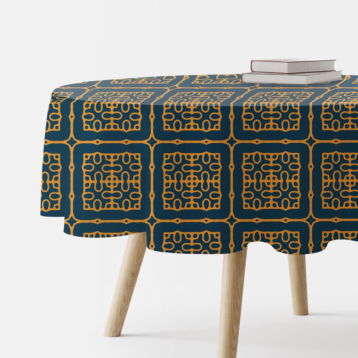 okrągły obrus z kafelkowym ornamentem w musztardowych i granatowych tonach na stole