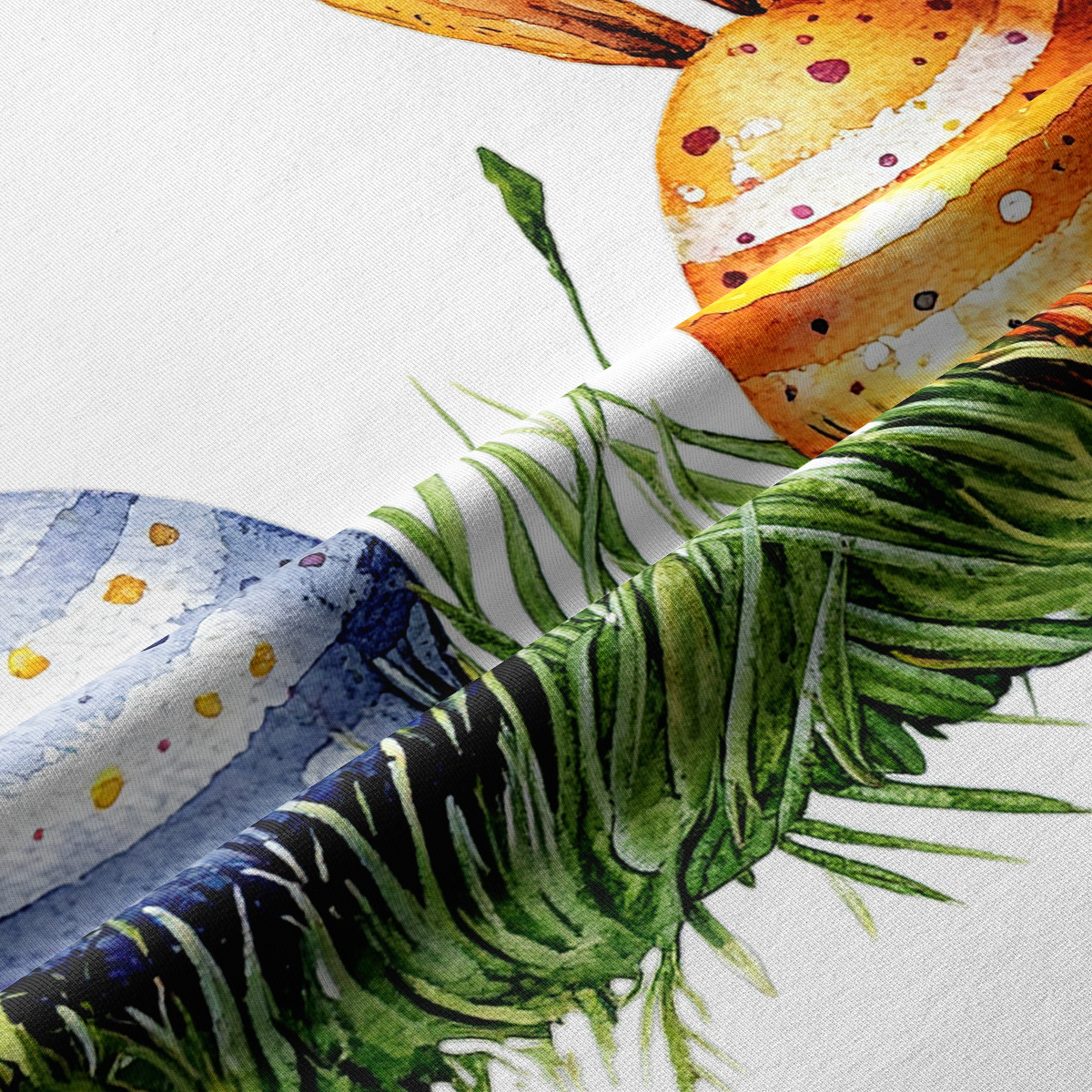 Zbliżenie na strukturę tkaniny i detal nadruku z pisankami oraz zielonymi źdźbłami trawy