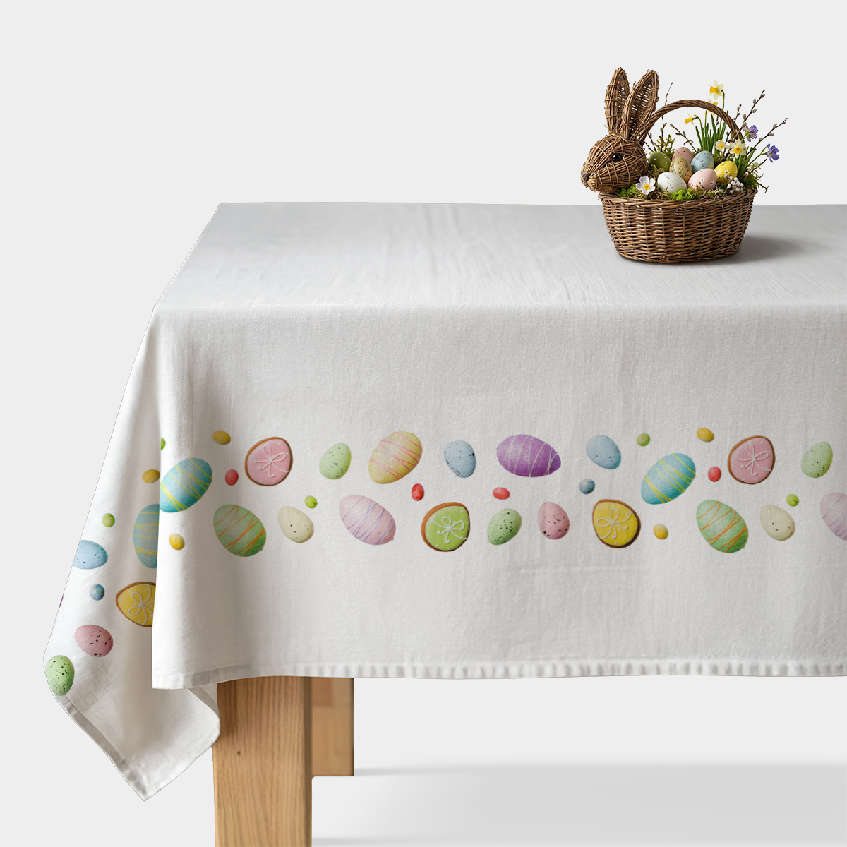 Obrus z pasem pastelowych pisanek i ciasteczek na białym tle, widok frontalny