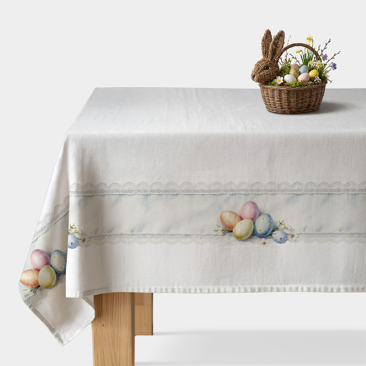 biały obrus ze wzorem pastelowych pisanek i koronkowym pasem na stole
