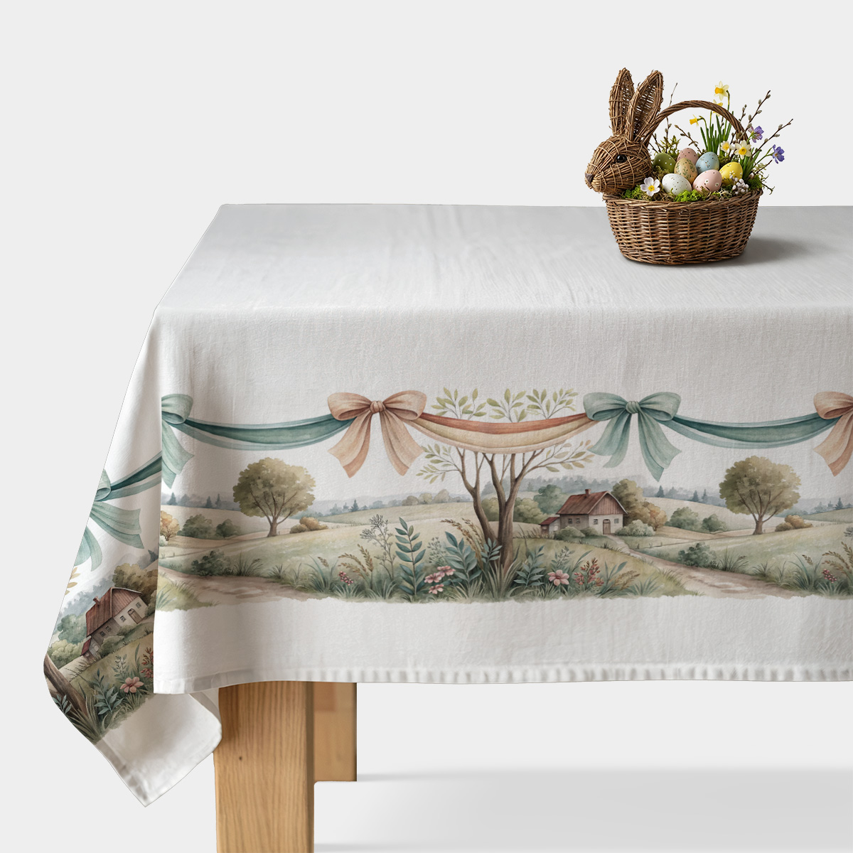 obrus z akwarelowym pejzażem i pastelowymi kokardami na białym tle