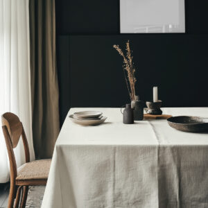 Aranżacja stołu z ceramiką i dekoracjami na kremowym obrusie