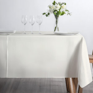 Minimalistyczne nakrycie stołu ze szkłem i wazonem na kremowym obrusie