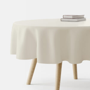okrągły stół przykryty kremowym, gładkim obrusem z książkami na blacie