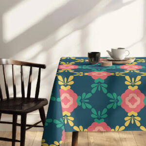 Bliższy kadr rogu obrusa z detalem zielonych liści i koralowego kwiatu