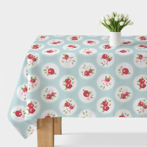 Obrus rozłożony na stole, miętowe tło z białymi medalionami i różowymi kwiatkami