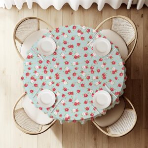 widok z góry na okrągły stół nakryty obrusem z różyczkami i ustawionymi talerzami